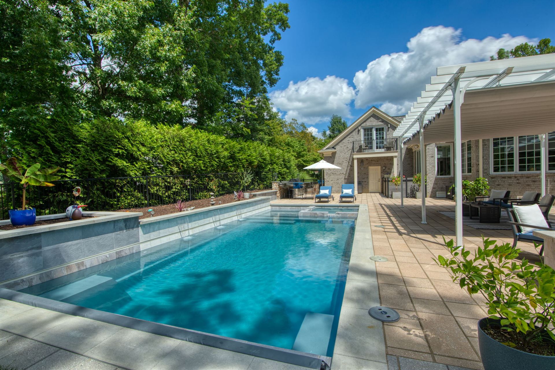 River Pools X36 in Diamond color with cascade, concrete paver patio, and natural stone coping