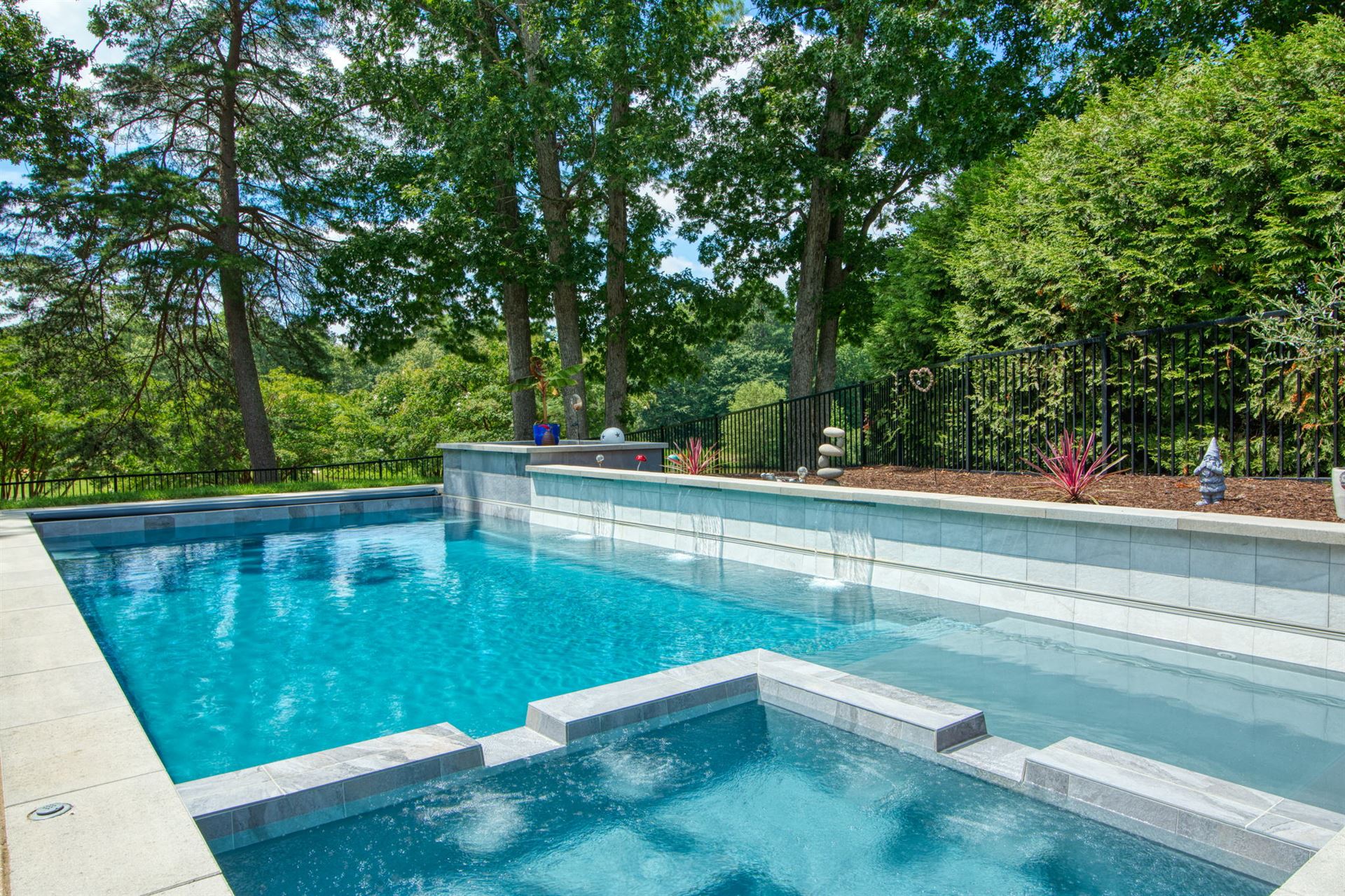 River Pools X36 in Diamond color with cascade, concrete paver patio, and natural stone coping
