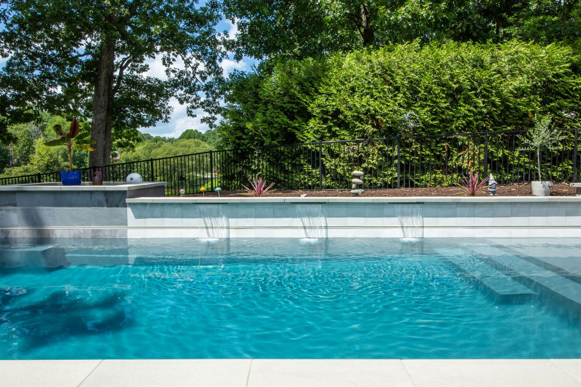 River Pools X36 in Diamond color with cascade, concrete paver patio, and natural stone coping