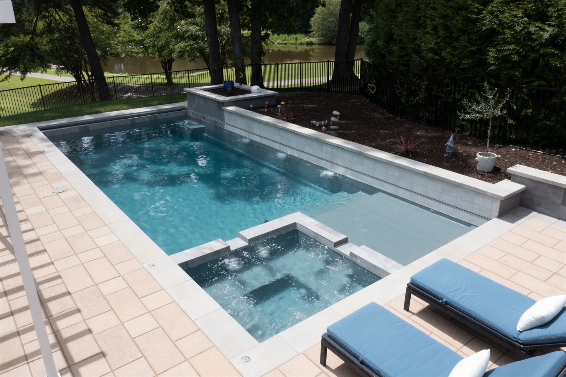 River Pools X36 in Diamond color with cascade, concrete paver patio, and natural stone coping