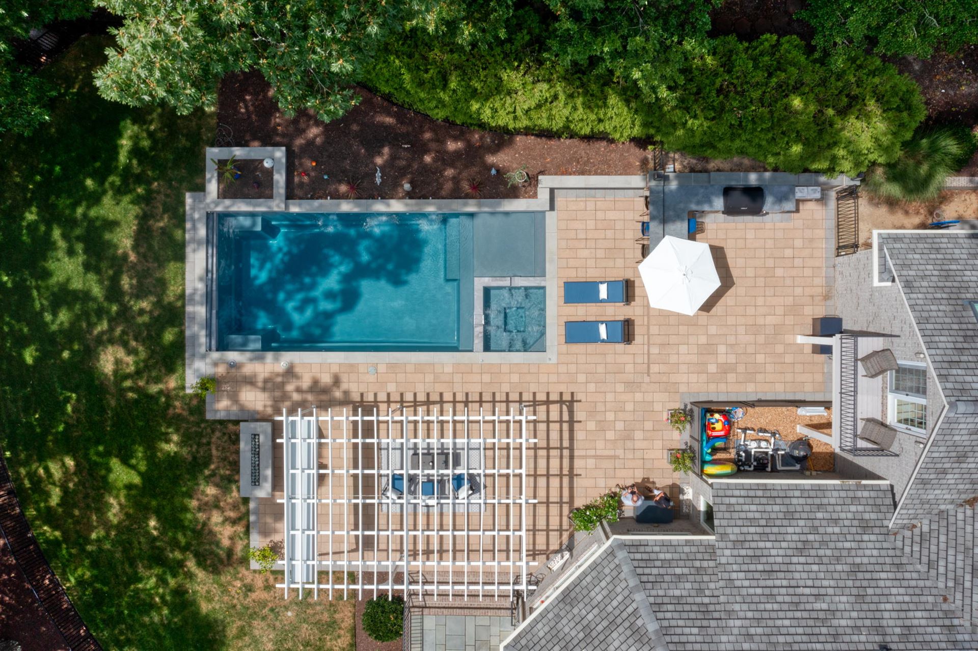 River Pools X36 in Diamond color with cascade, concrete paver patio, and natural stone coping