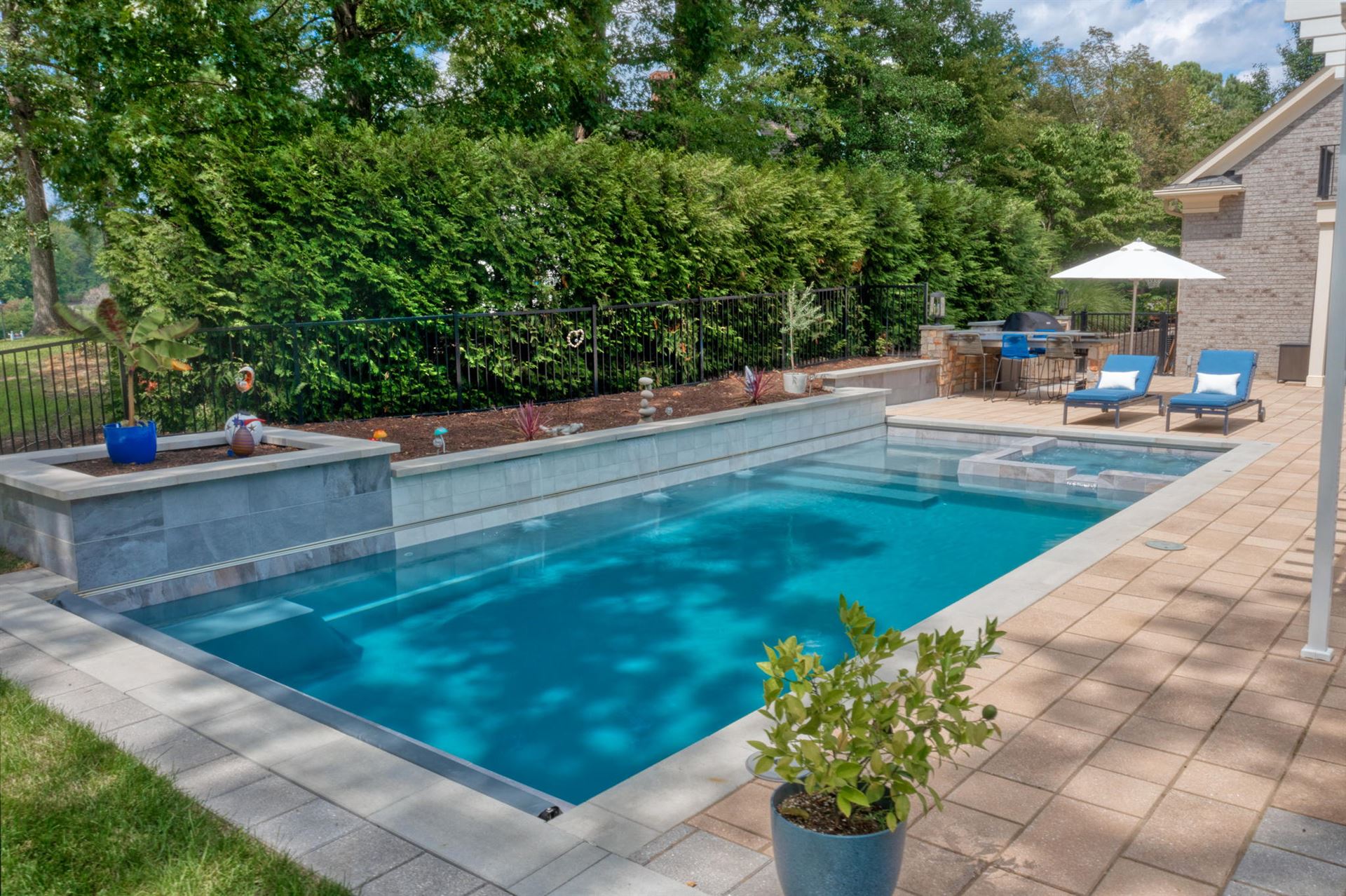 River Pools X36 in Diamond color with cascade, concrete paver patio, and natural stone coping