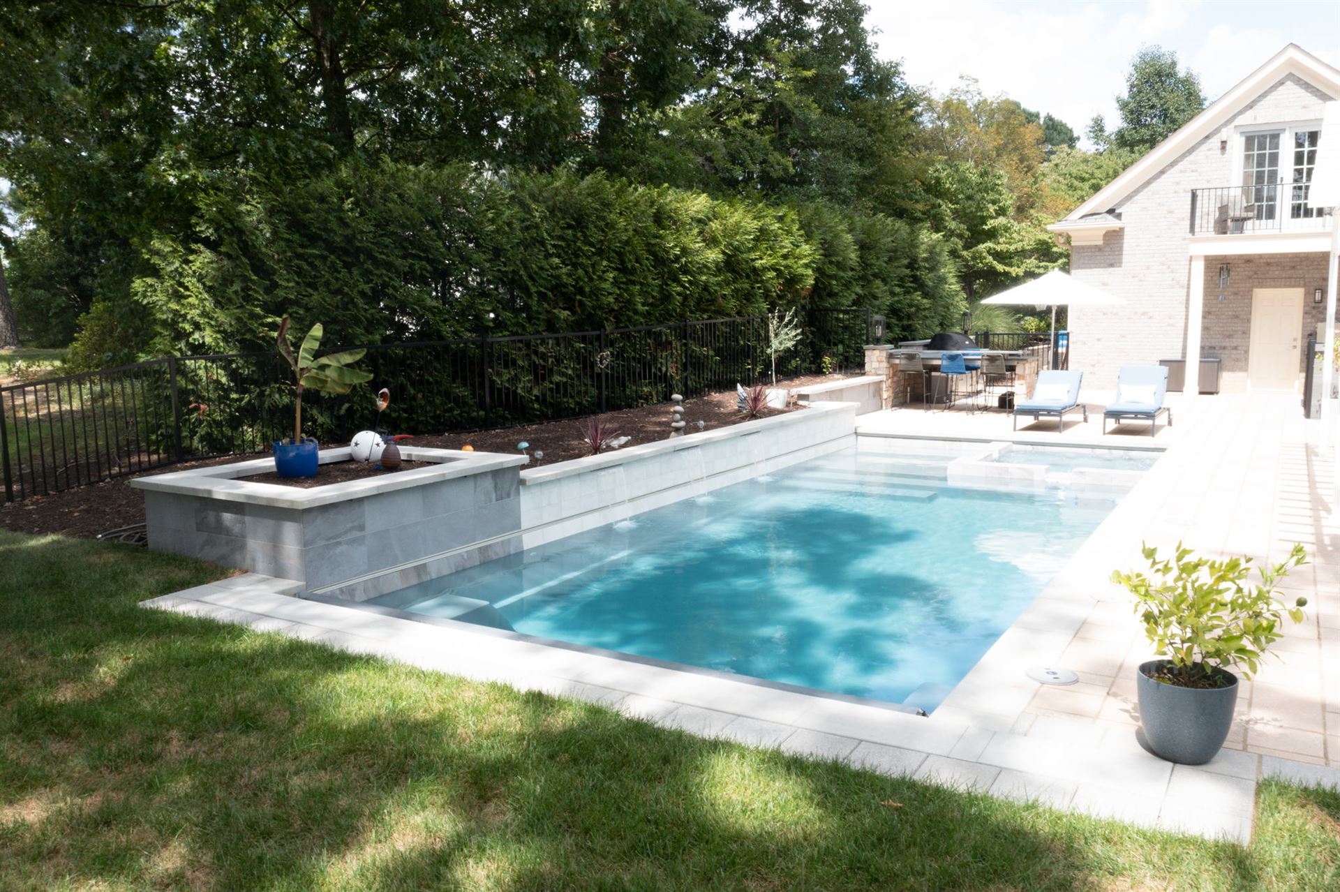 River Pools X36 in Diamond color with cascade, concrete paver patio, and natural stone coping