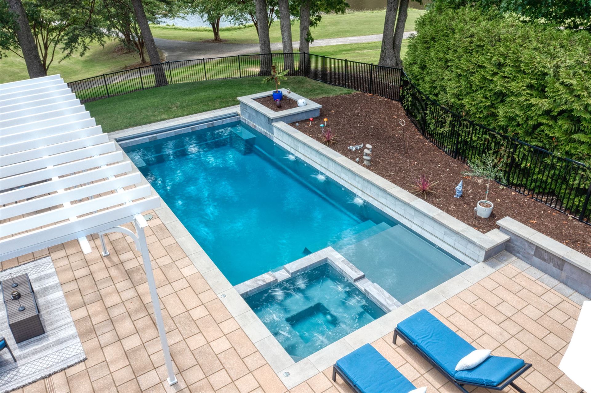 River Pools X36 in Diamond color with cascade, concrete paver patio, and natural stone coping
