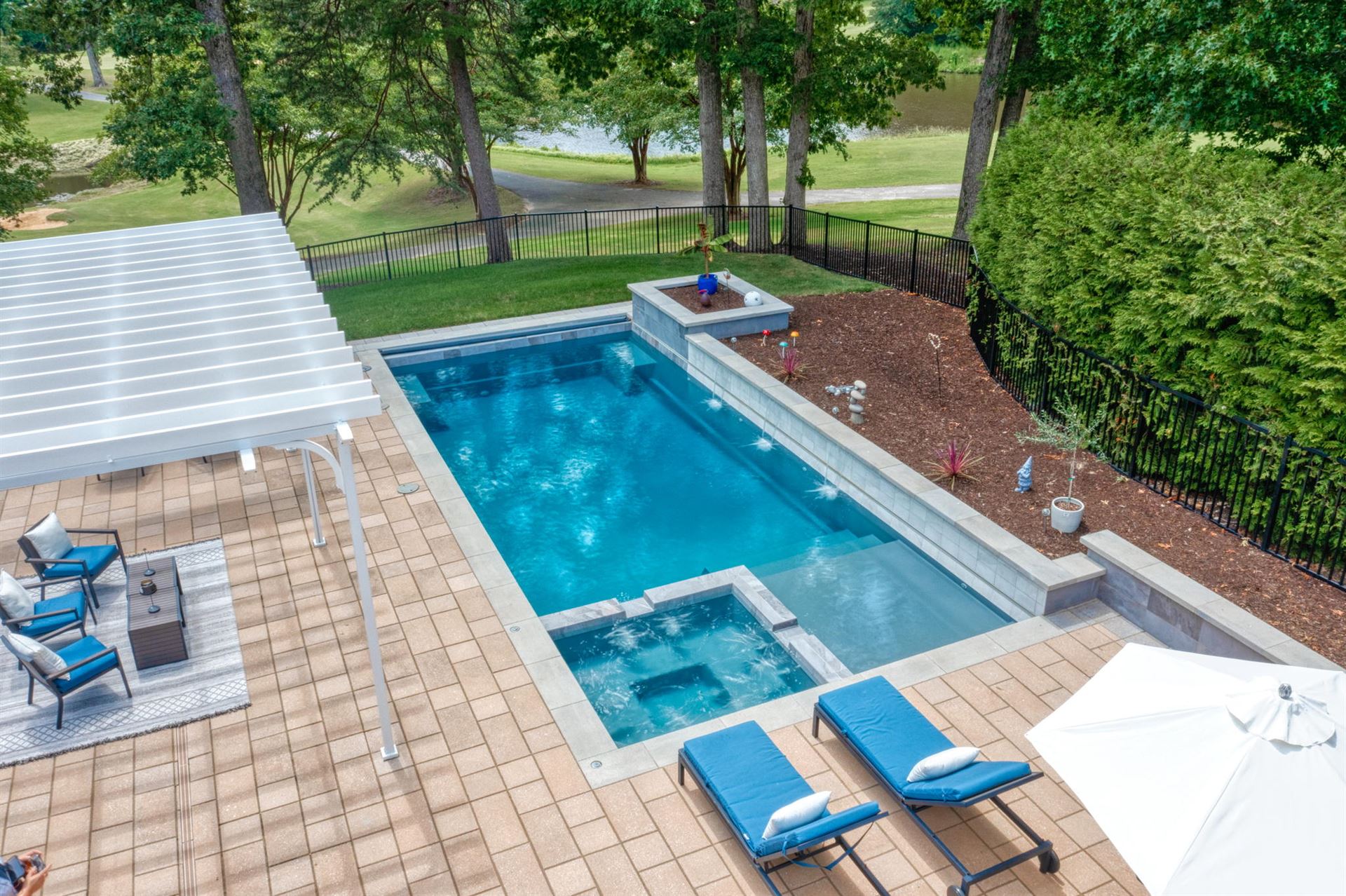 River Pools X36 in Diamond color with cascade, concrete paver patio, and natural stone coping