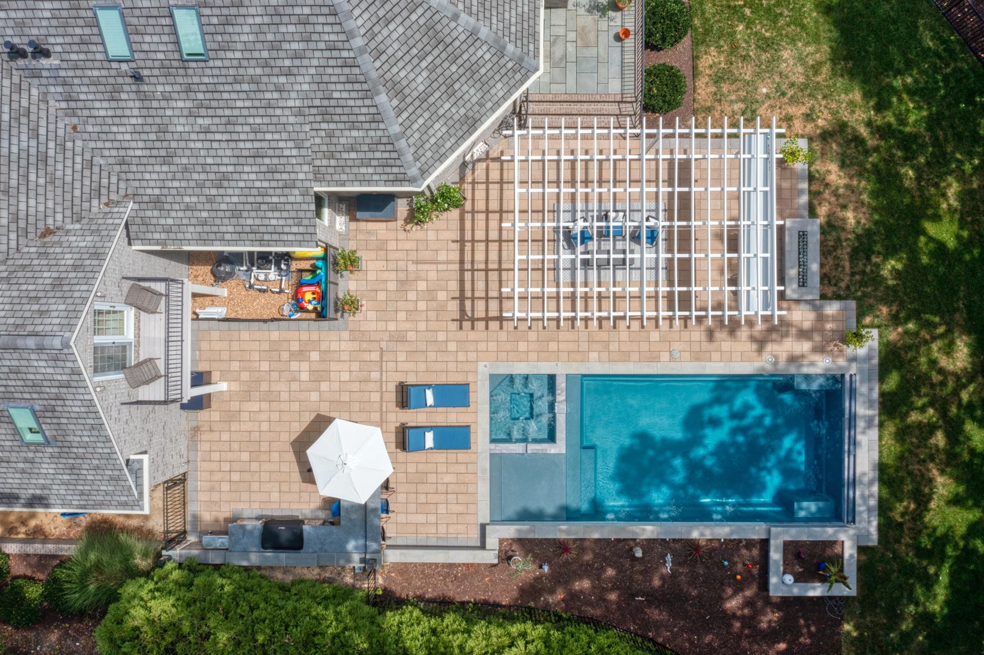 River Pools X36 in Diamond color with cascade, concrete paver patio, and natural stone coping