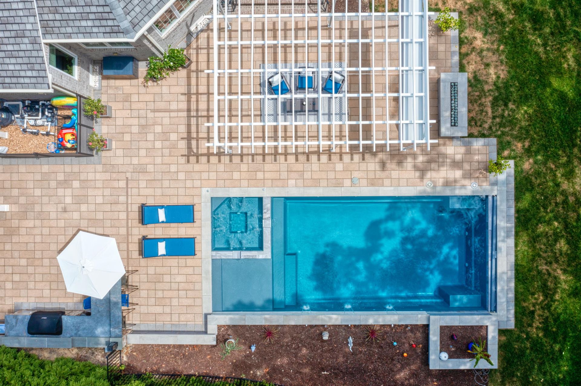 River Pools X36 in Diamond color with cascade, concrete paver patio, and natural stone coping