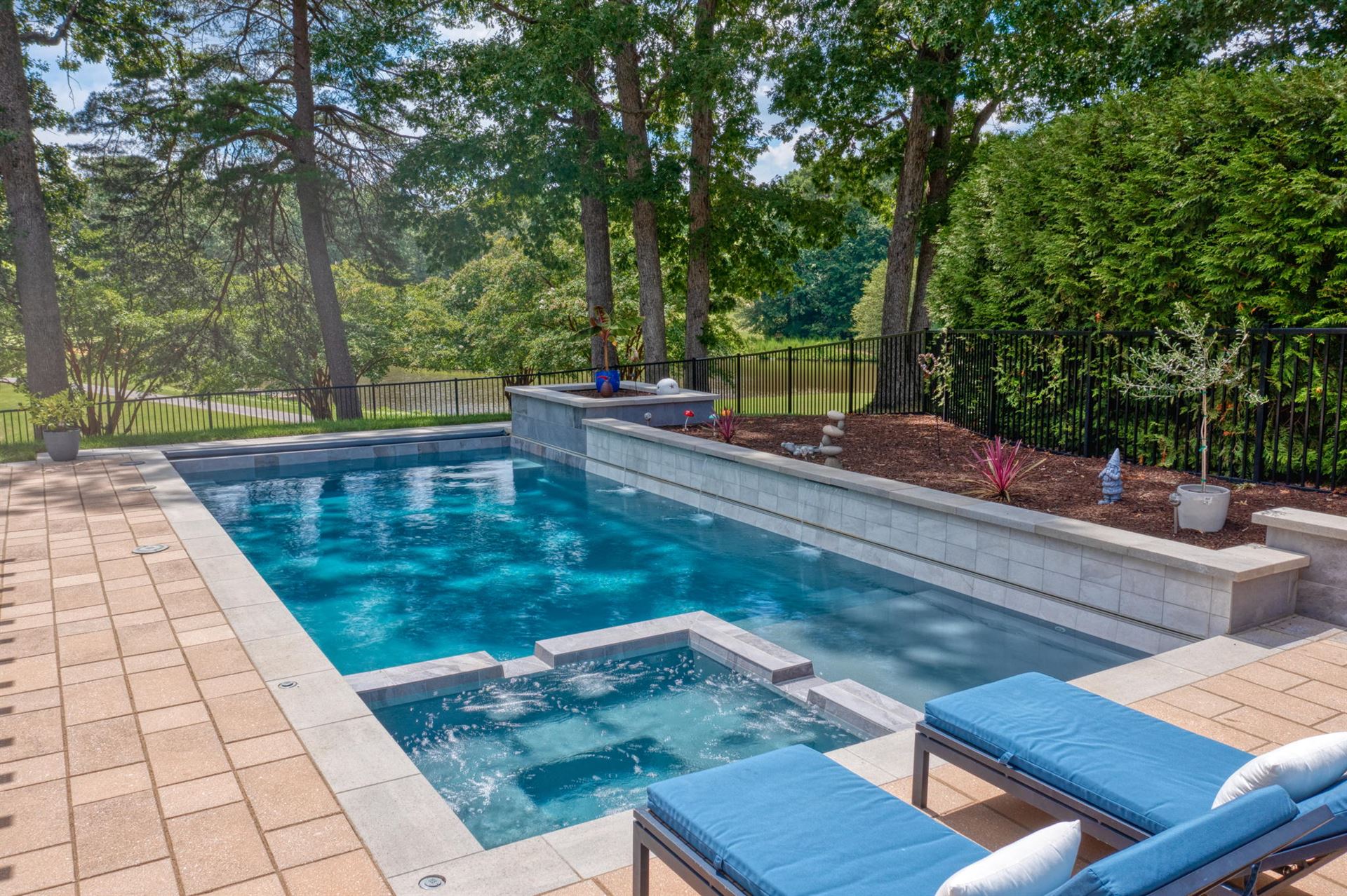 River Pools X36 in Diamond color with cascade, concrete paver patio, and natural stone coping